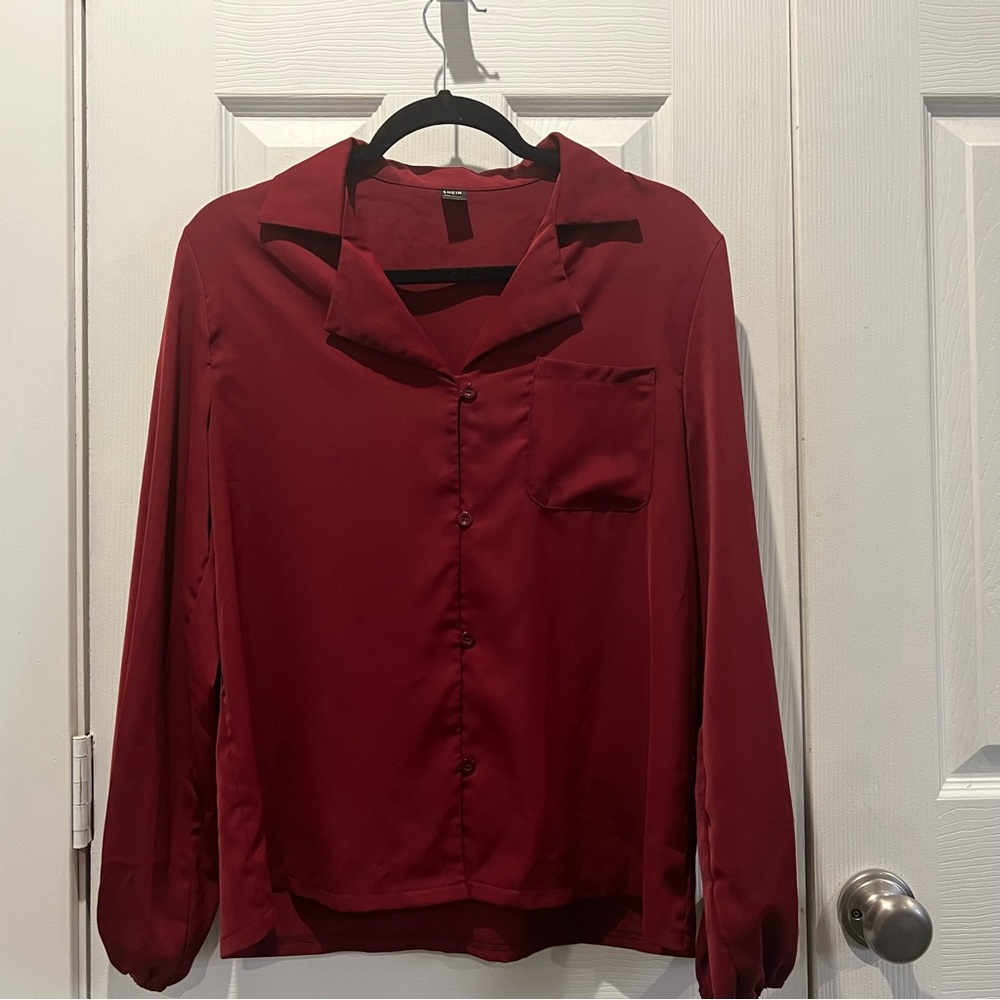 Red shirt, made of a smooth satin material. Long sleeves, pocket and collar.